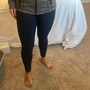 Navy blue lulu lemon leggings with reflective bottom design and pockets